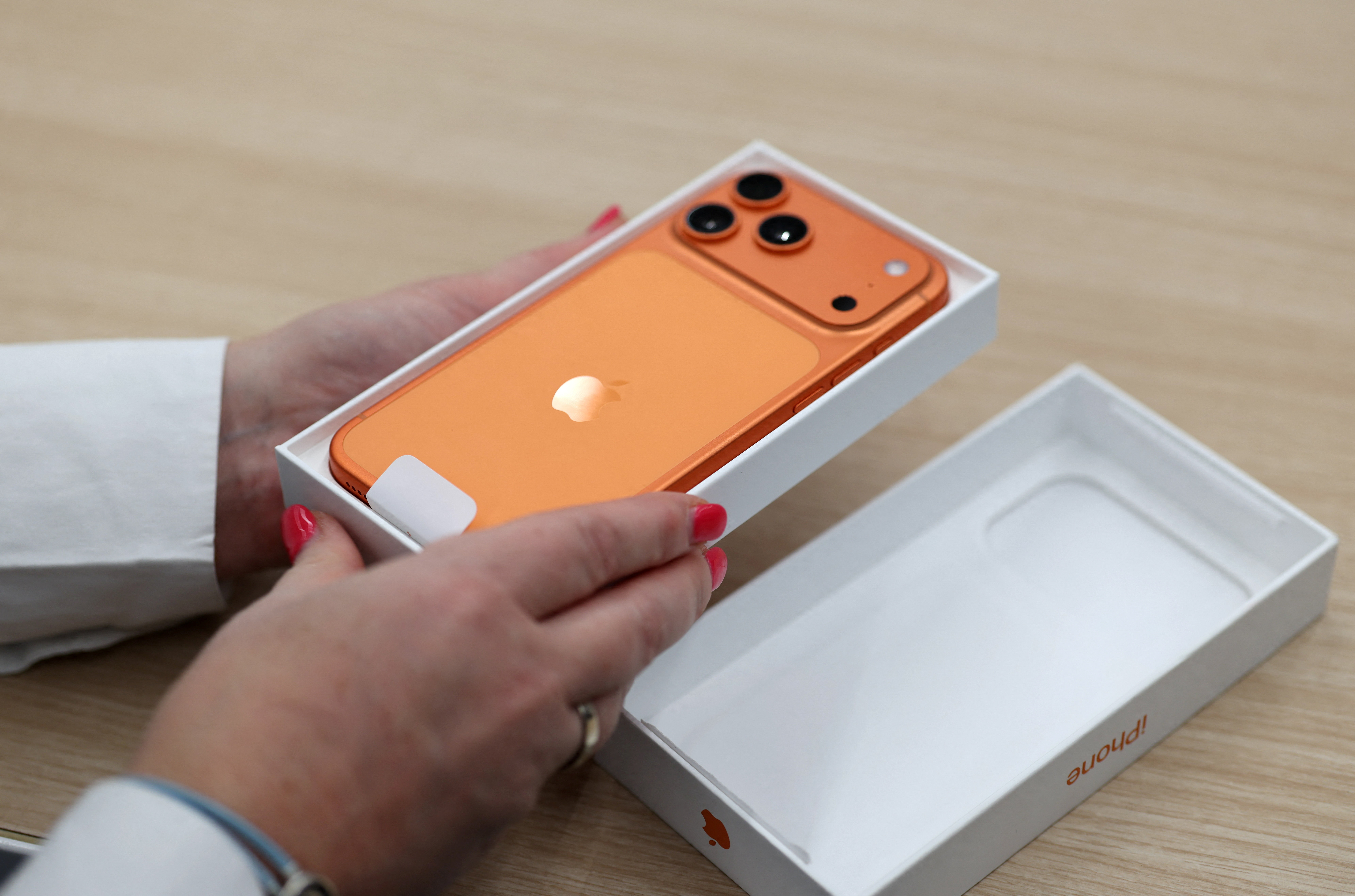 An employee uses Apple's new iPhone 17 smartphone, which is demonstrated in a store during preparations for the series' launch of sales in Moscow, Russia. (Reuters)